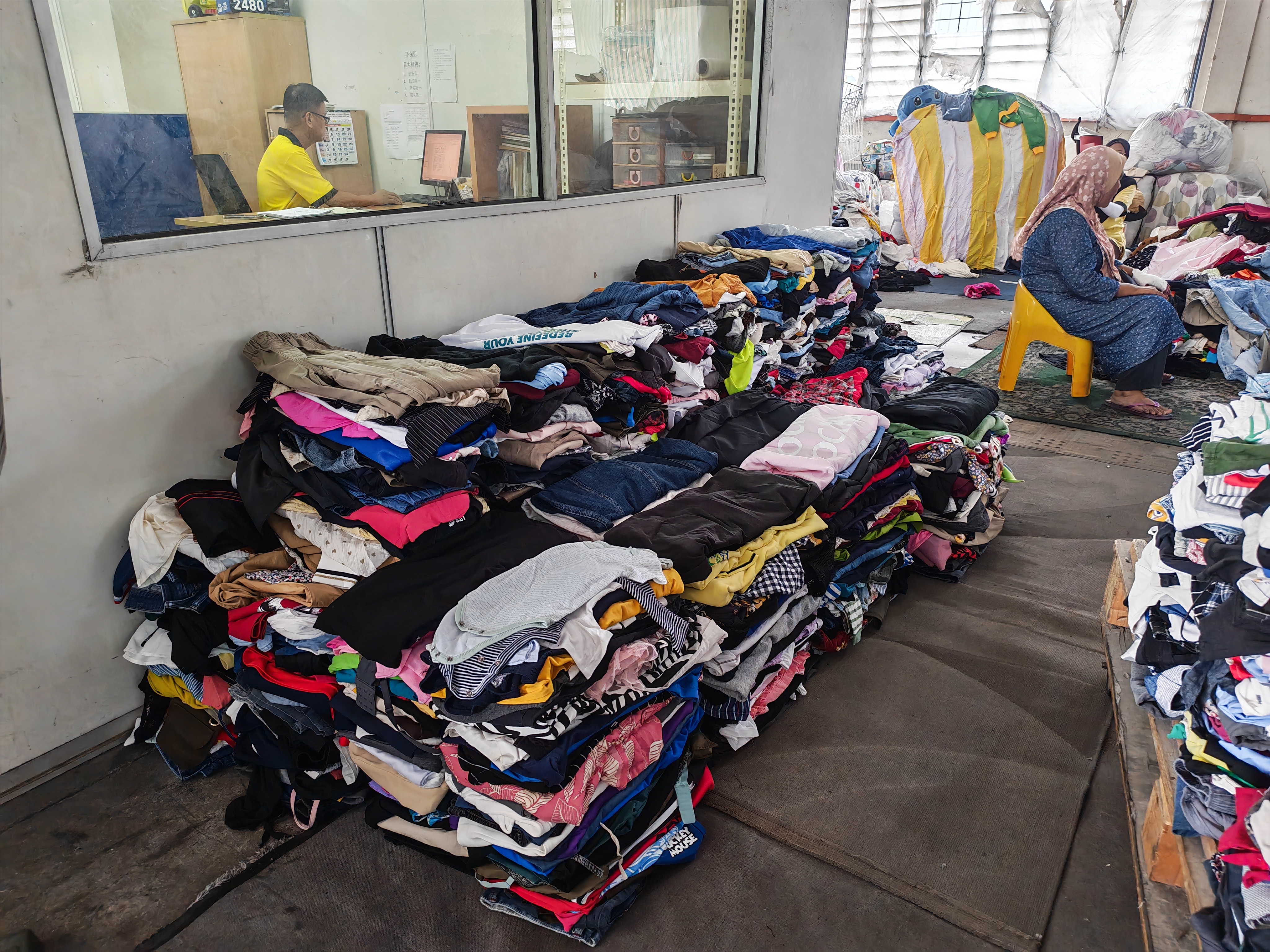 Person dropping off bag of clothes at Yellow Bin in Johor Bahru — free textile recycling